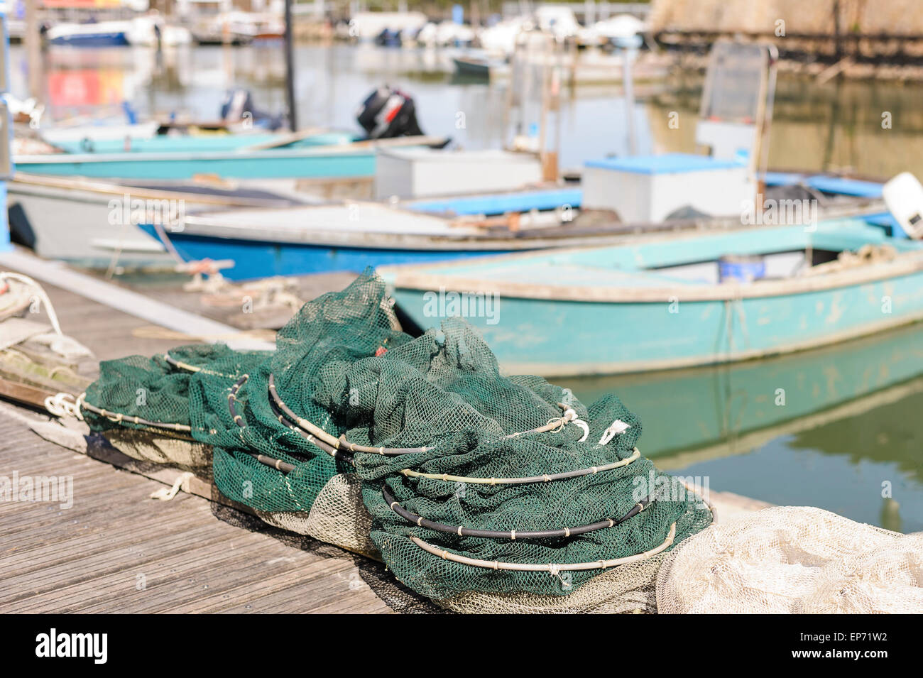 Le reti da pesca in banchina, in background le barche da pesca Foto Stock