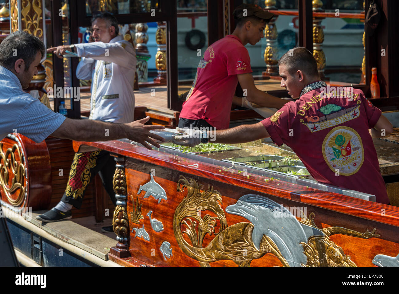 Un kebab di pesce che viene fatto passare da un balık-ekmek barca accanto al Ponte di Galata a Istanbul Foto Stock