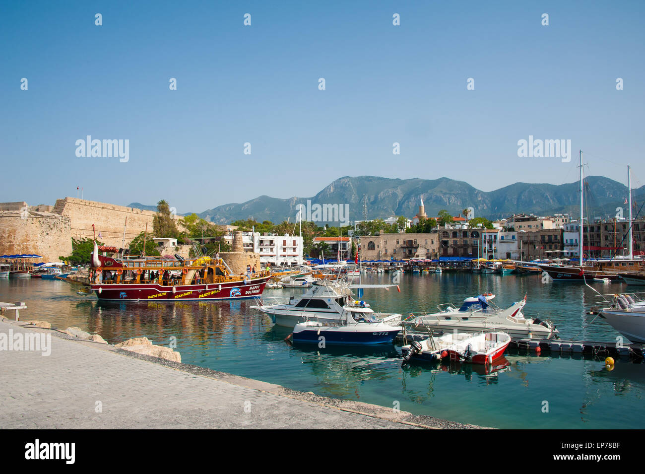 Turistiche e di imbarcazioni private di Kyrenia, Girne Harbour, con le montagne sullo sfondo e il castello in rovina, Cipro del Nord Foto Stock