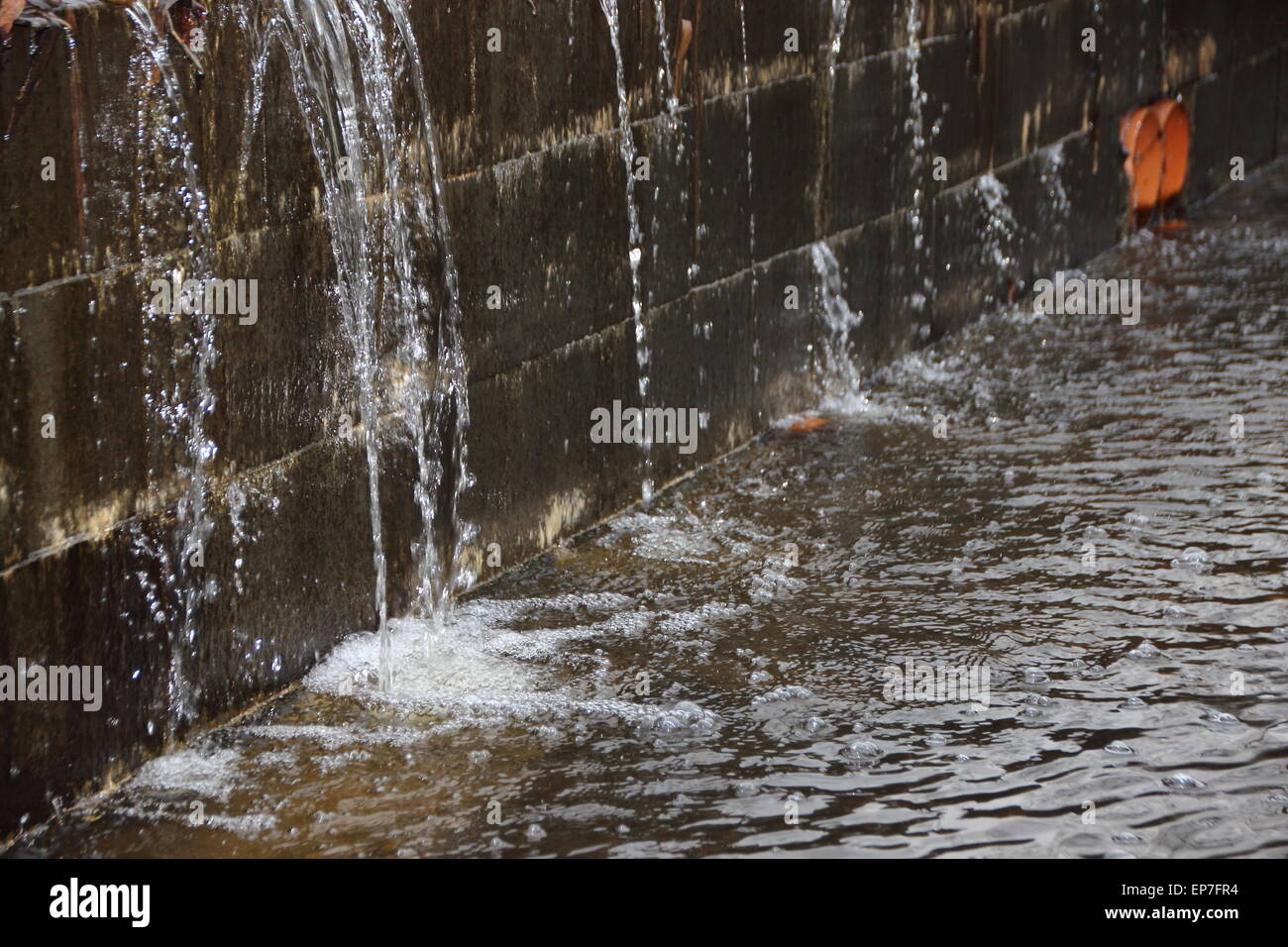 Argine sotto la pressione dell'acqua con acqua di irrorazione e la creazione di una piccola cascata Foto Stock