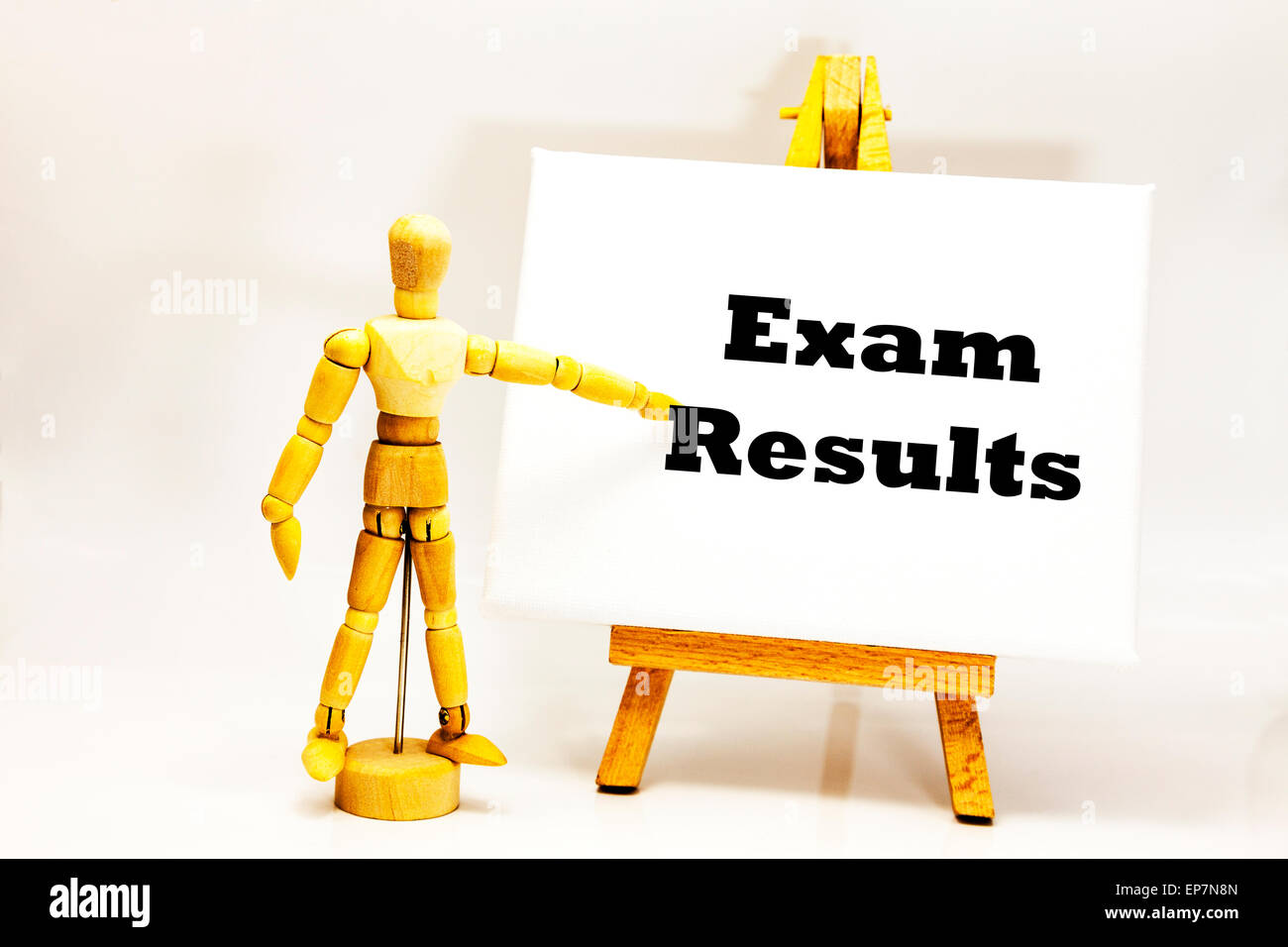 Wooden man with white board pointing at words "Exam Results" sats school exam revision o' levels diploma future matter important Foto Stock