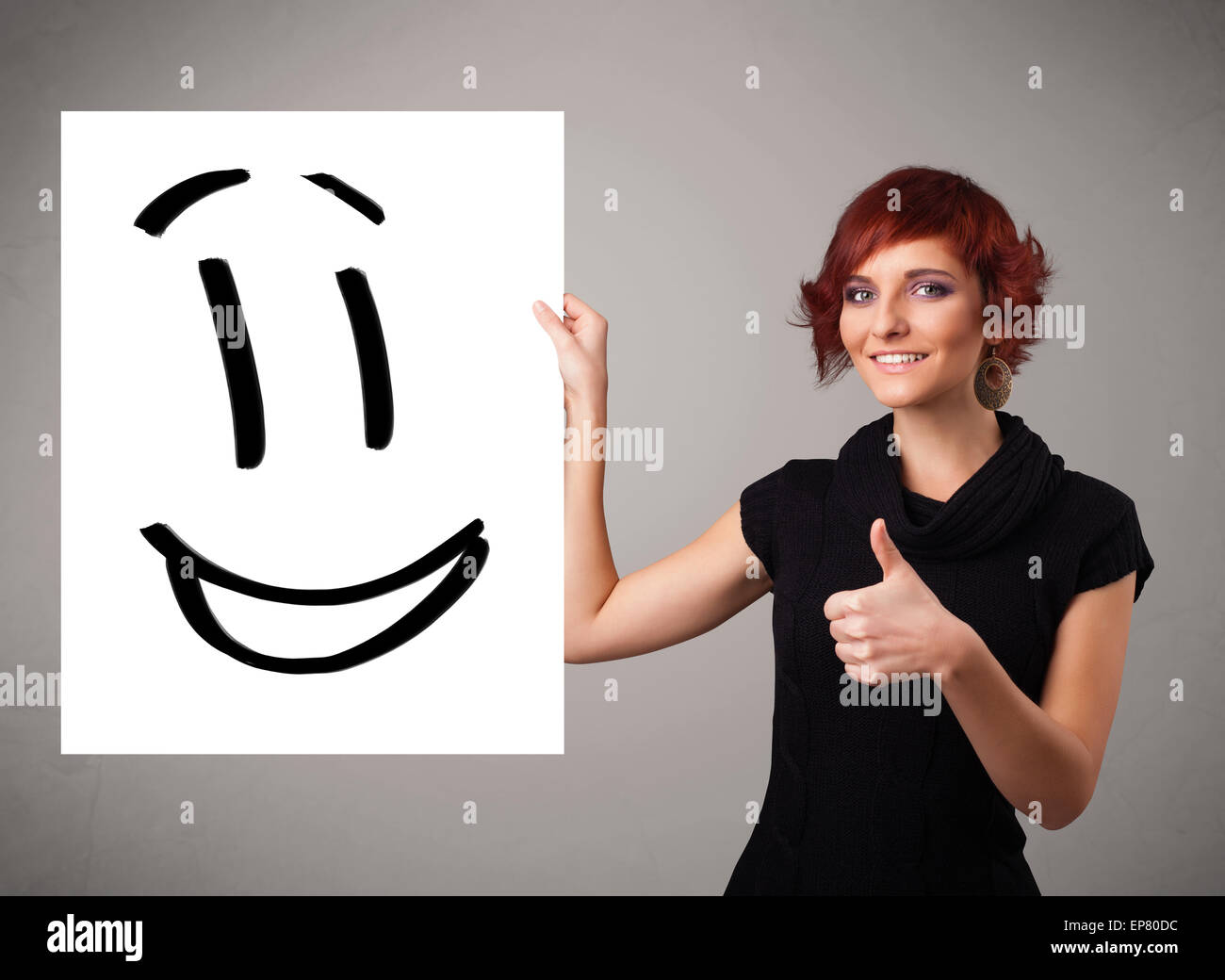 Giovane donna azienda Smiley face disegno Foto Stock