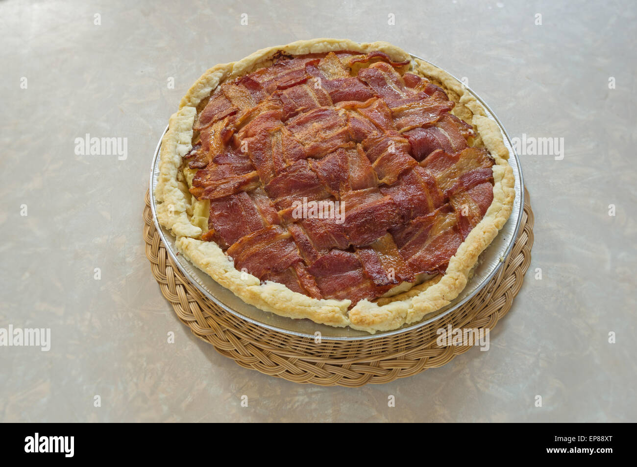 Home realizzati bacon traliccio top purea di torta di patate seduto sul tavolo su un vimini pad a caldo Foto Stock