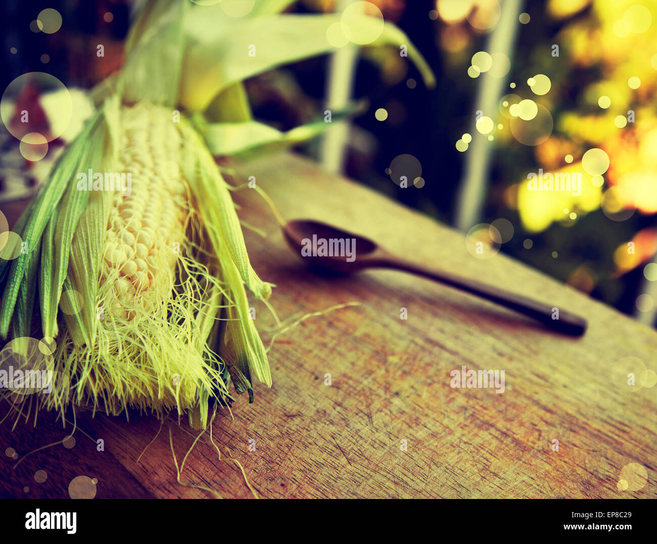 Orecchio di mais, il cucchiaio di legno sul vecchio tavolo in legno, alimentari sfondo, tema di caduta Foto Stock