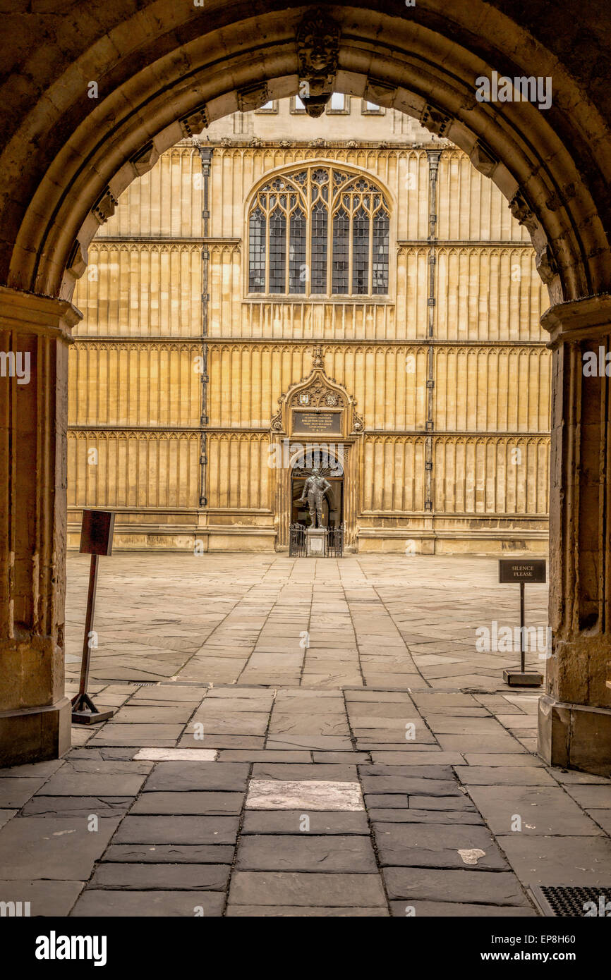 Cortile della biblioteca Bodleian Library e la statua di Sir Thomas Bodley (studioso e fondatore della libreria) Oxford, Inghilterra, Regno Unito. Foto Stock