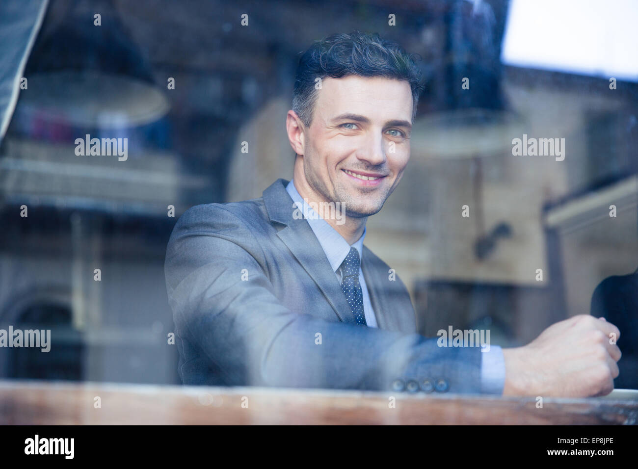 Ritratto di un imprenditore allegro seduti a tavola in cafe Foto Stock