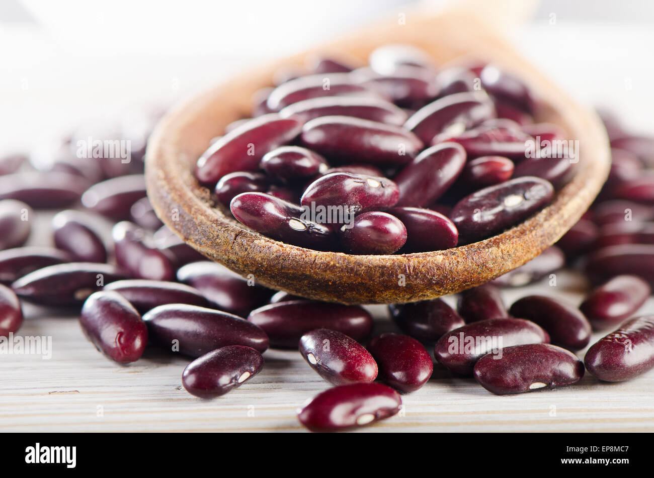 Fagioli rossi in cucchiaio di legno. Messa a fuoco selettiva Foto Stock