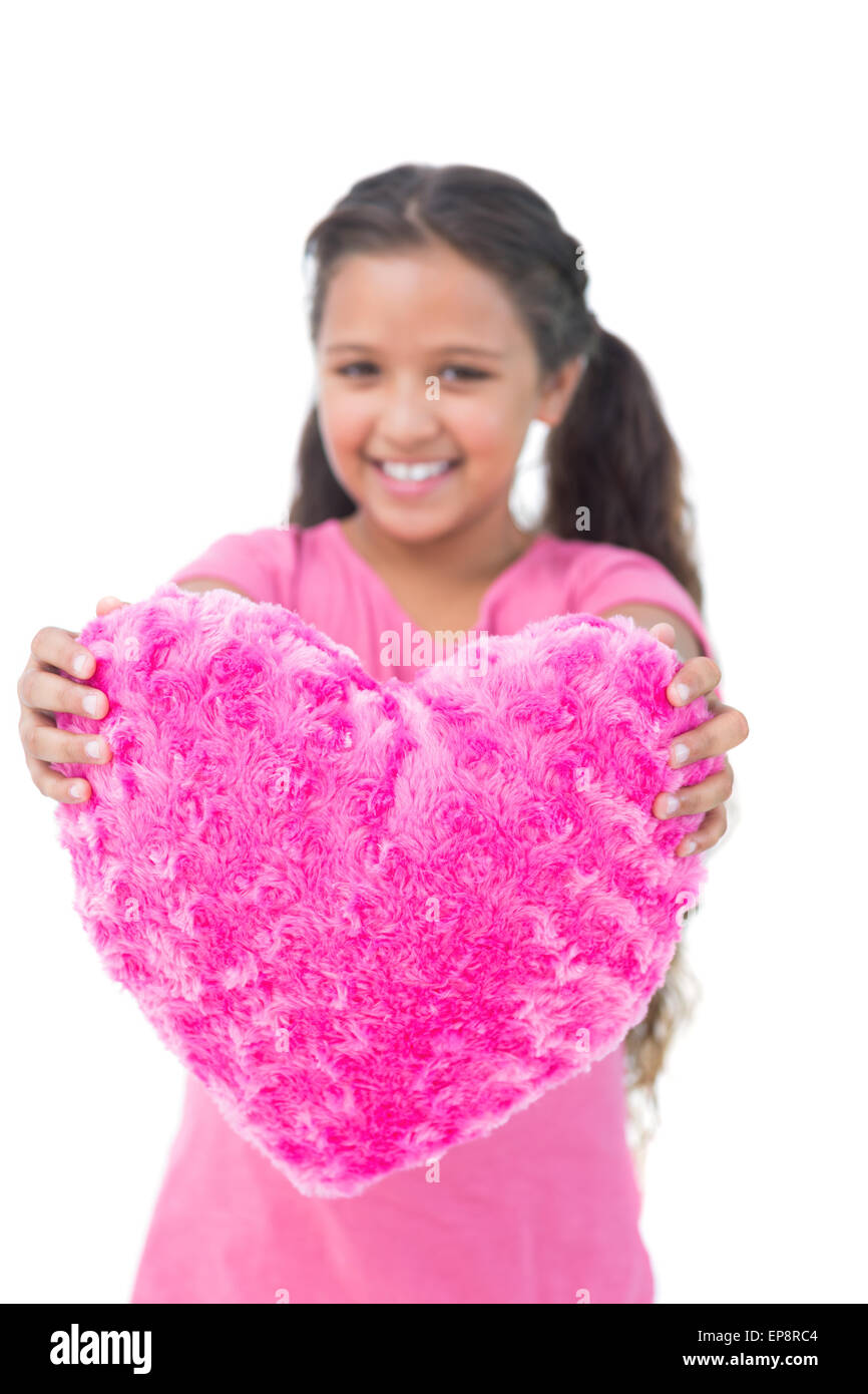 Bambina che mostra il cuscino a forma di cuore Foto Stock