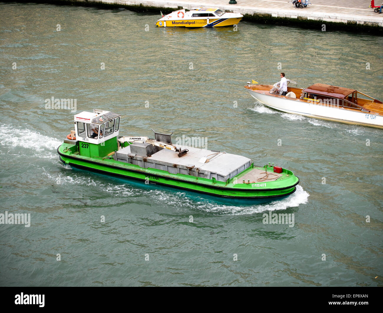 Un verde barca commerciale sul Canal Grande a Venezia Foto Stock