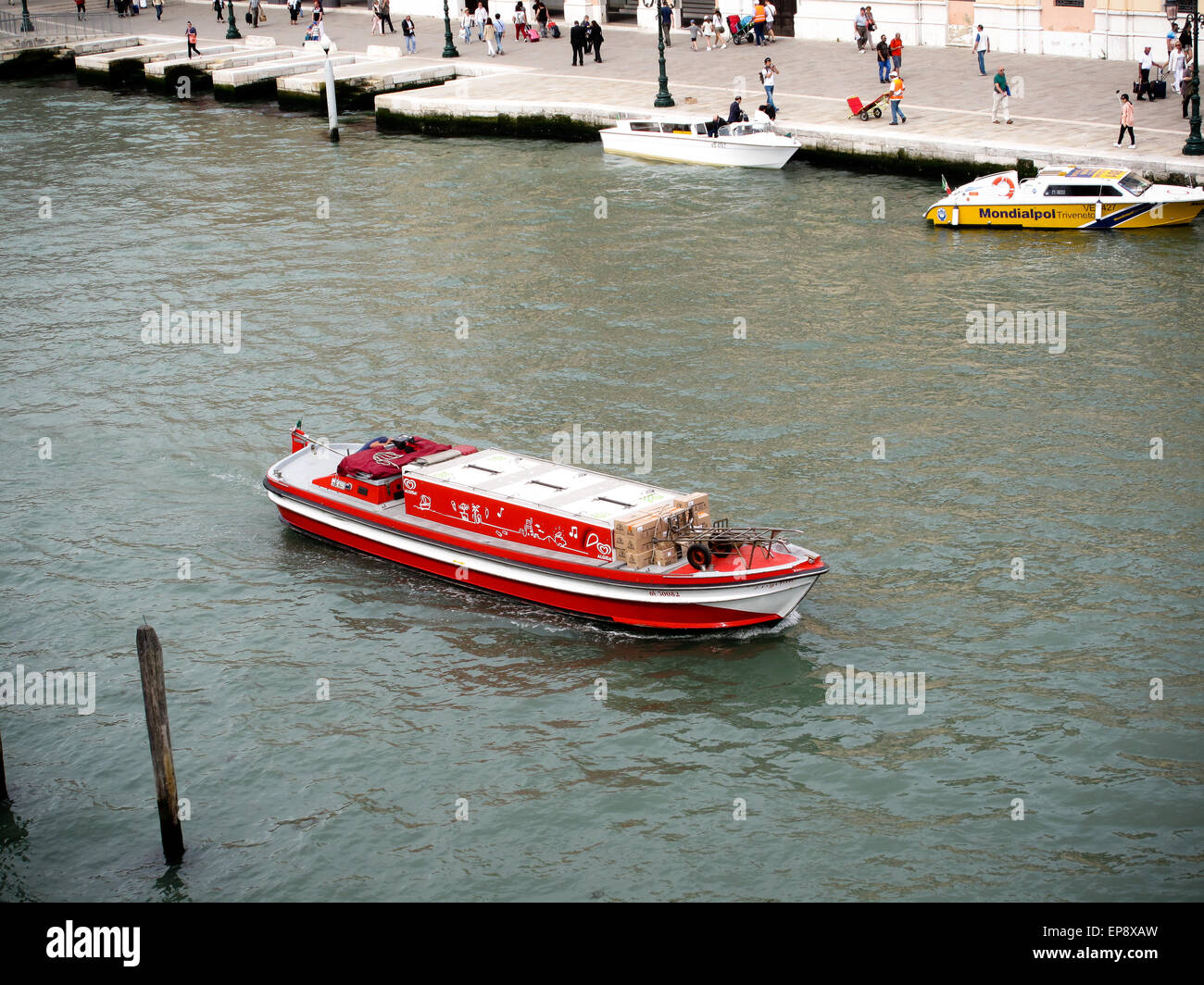 Un rosso barca commerciale sul Canal Grande a Venezia Foto Stock