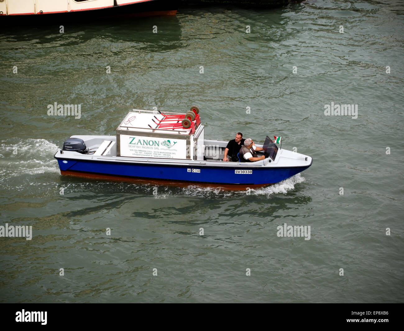 Una barca di lavoro con un vano congelatore,offrendo alimenti congelati da acqua , a Venezia Foto Stock