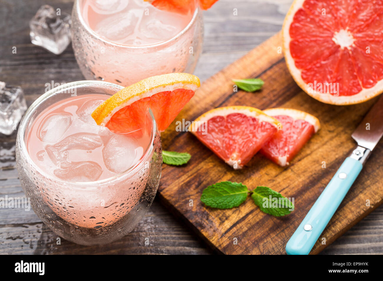 Cocktail con succo di pompelmo fetta su un tavolo di legno Foto Stock