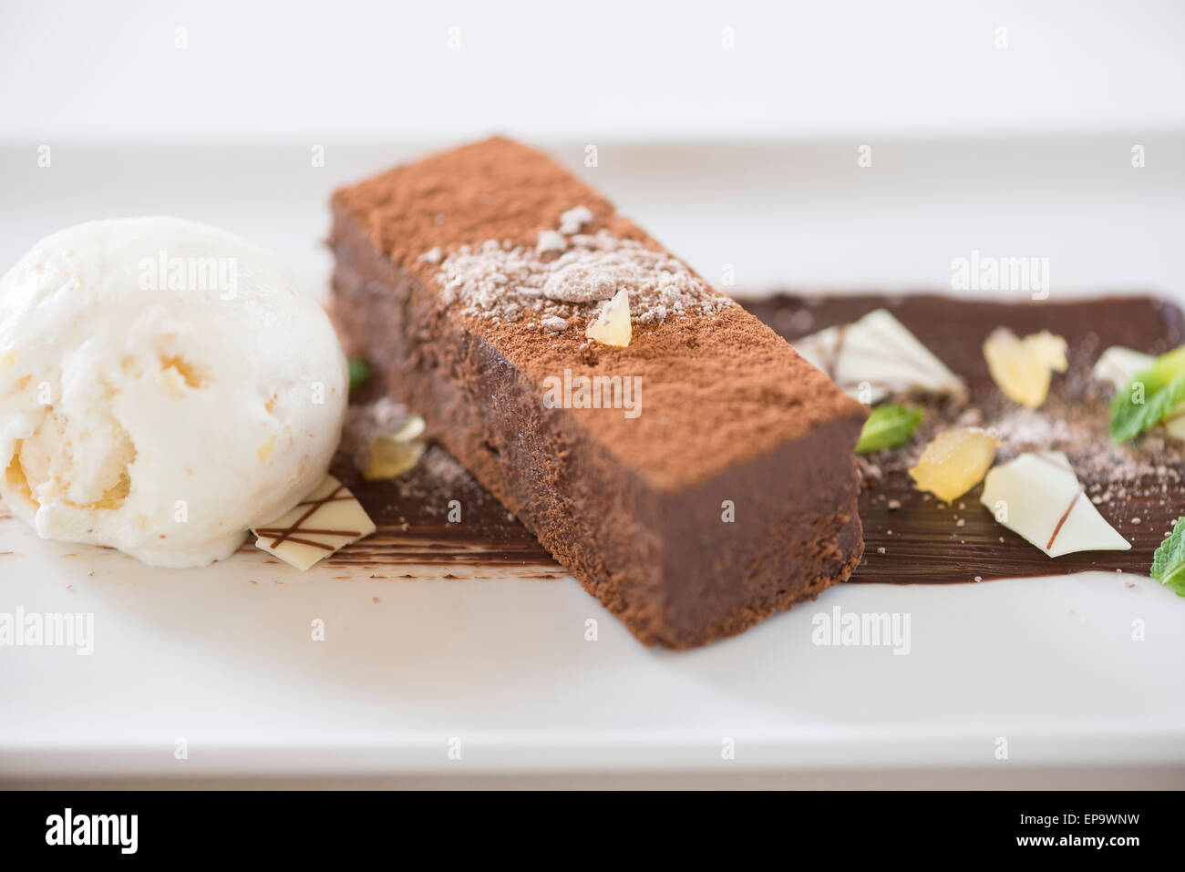 Il cioccolato brownice servita con gelato e cioccolato bianco Foto Stock