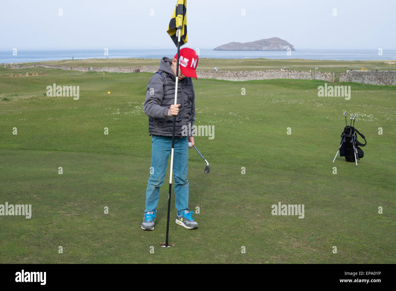 10 anno vecchio ragazzo giocando a golf Foto Stock