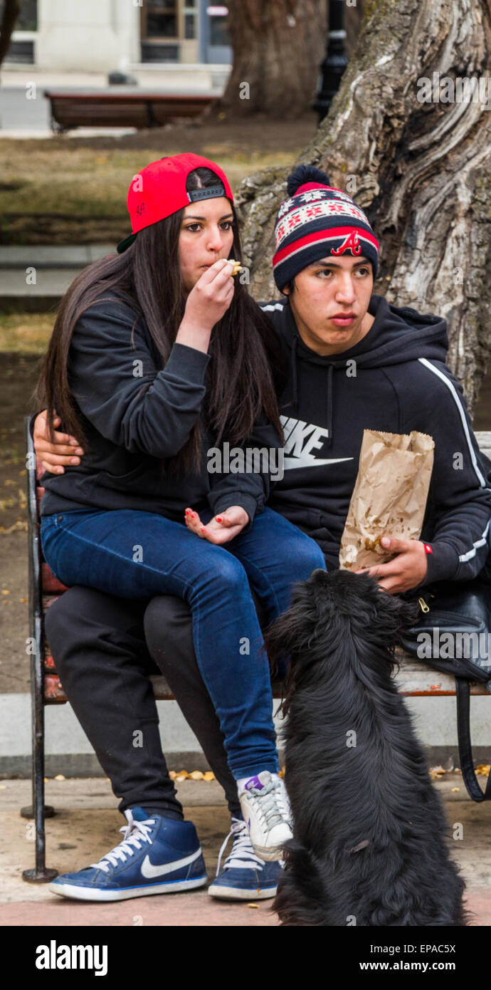 Ragazza seduta sul ragazzo del ginocchio, Plaza de Armas, Punta Arenas, Cile Foto Stock