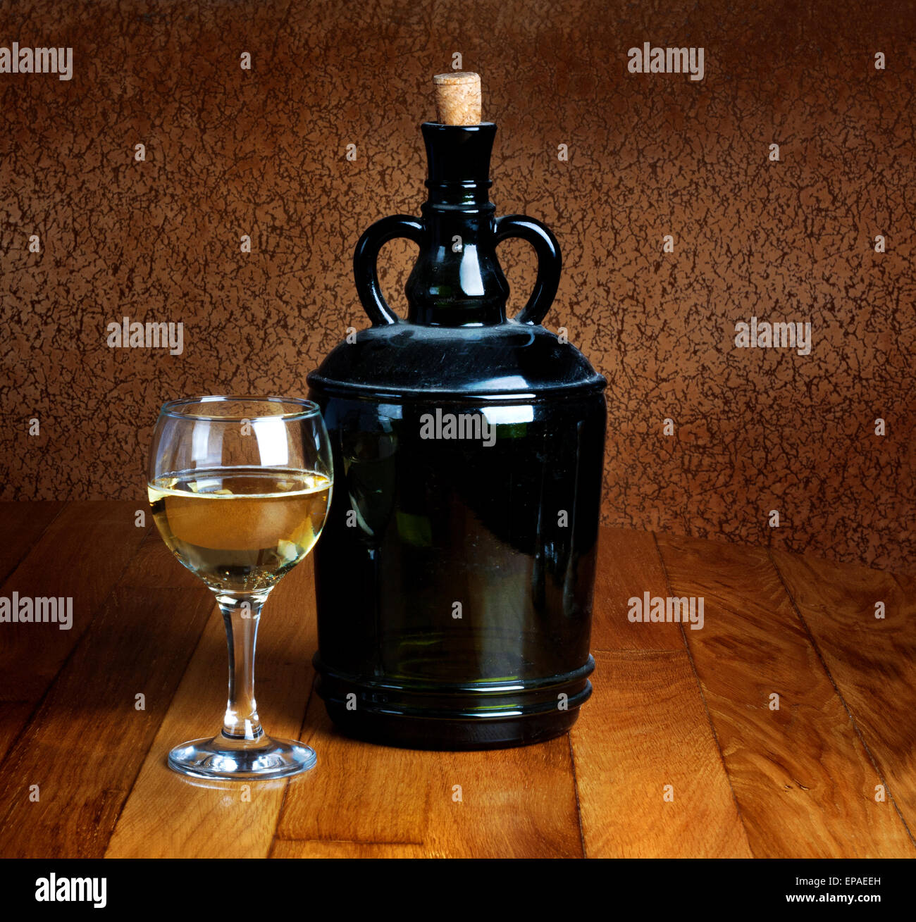 Polveroso vecchia bottiglia e bicchiere di vino bianco su di un tavolo di legno Foto Stock