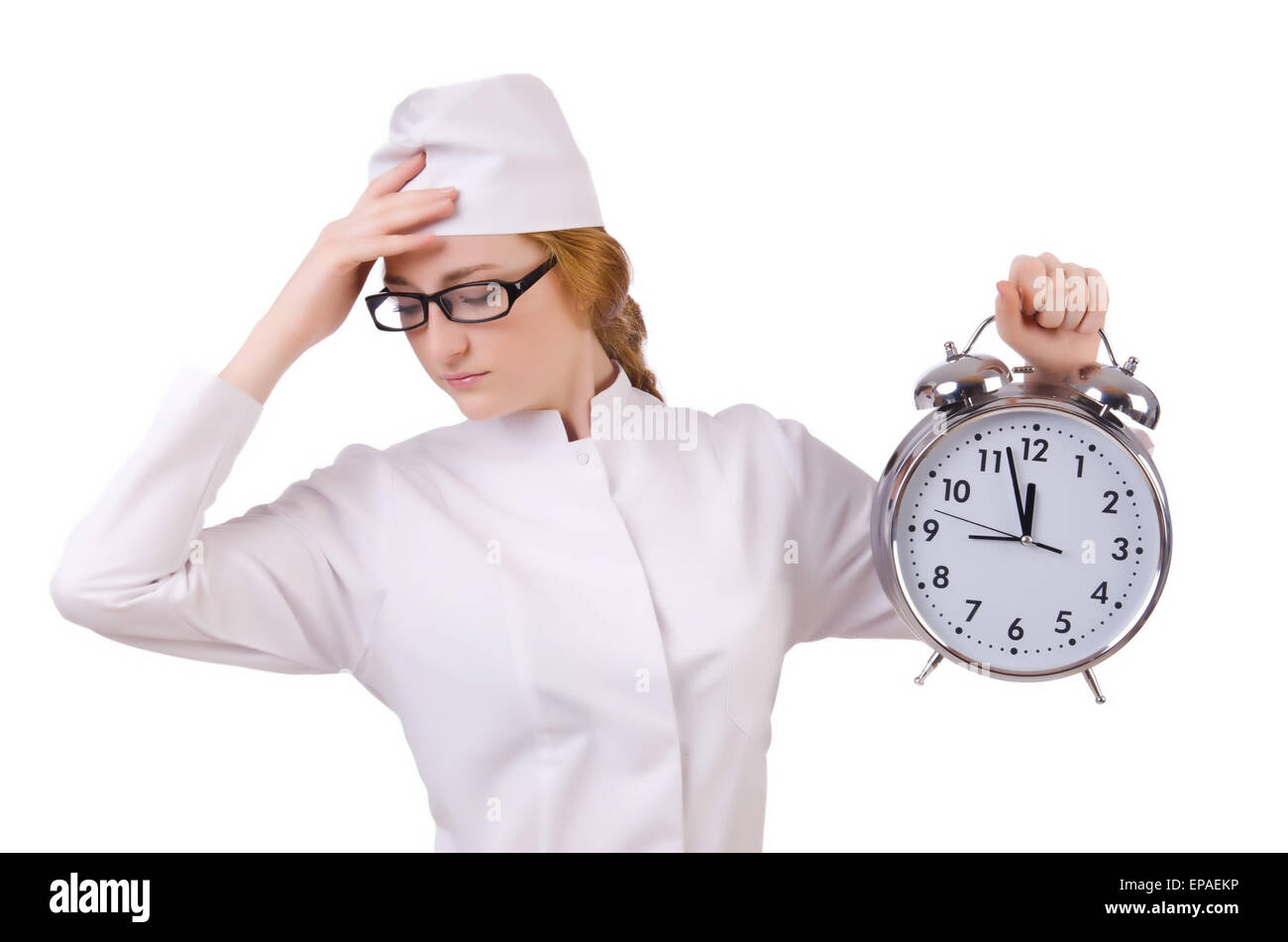 Attraente ha sottolineato la donna medico con grande orologio isolato su bianco Foto Stock