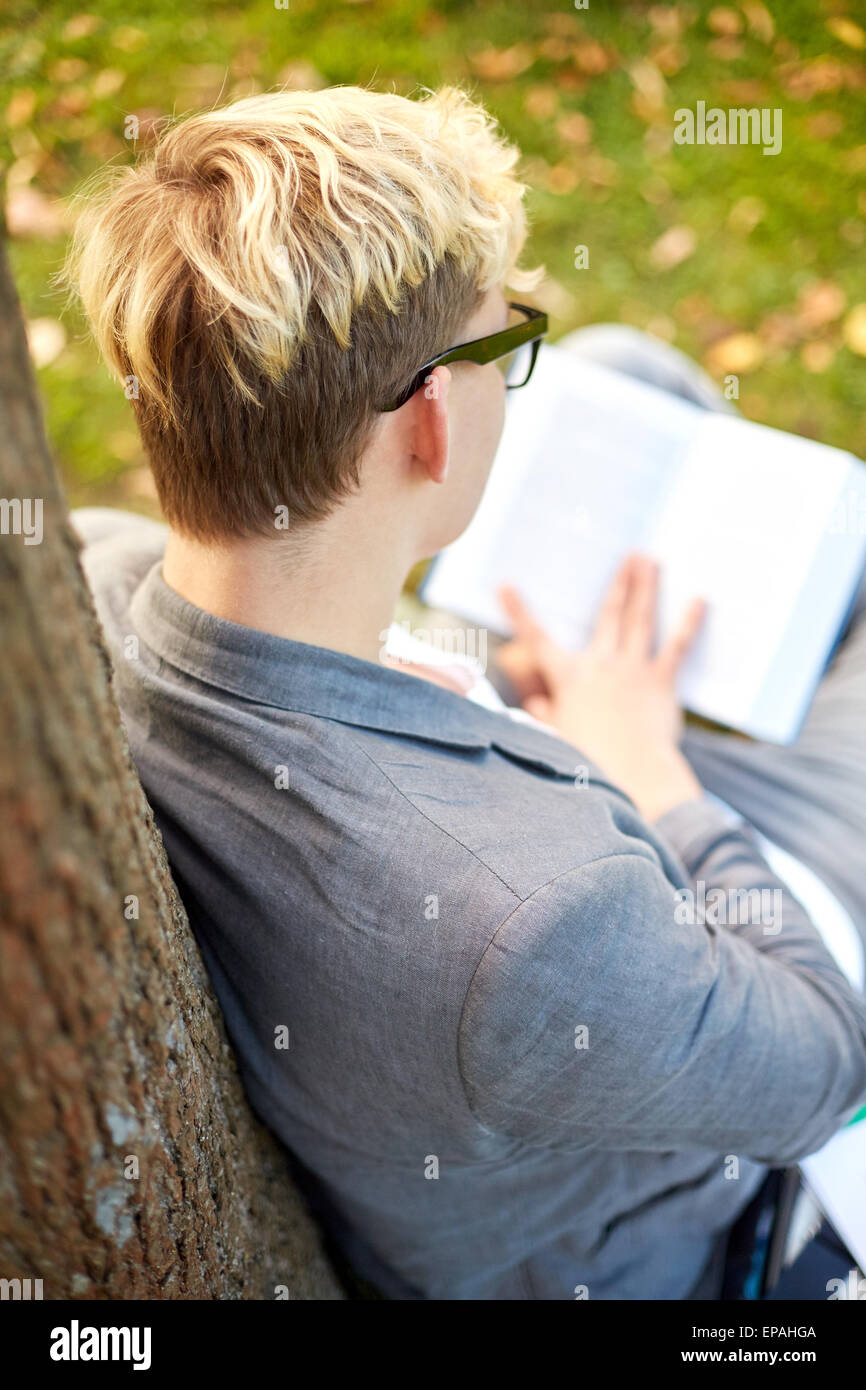 Ragazzo adolescente o giovane libro lettura all'aperto Foto Stock