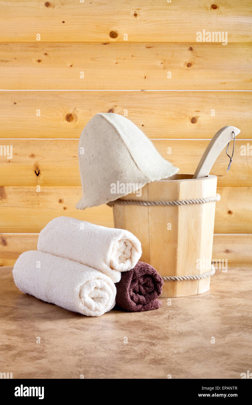 Tradizionale sauna in legno per il relax con secchio di acqua e set di asciugamani puliti Foto Stock