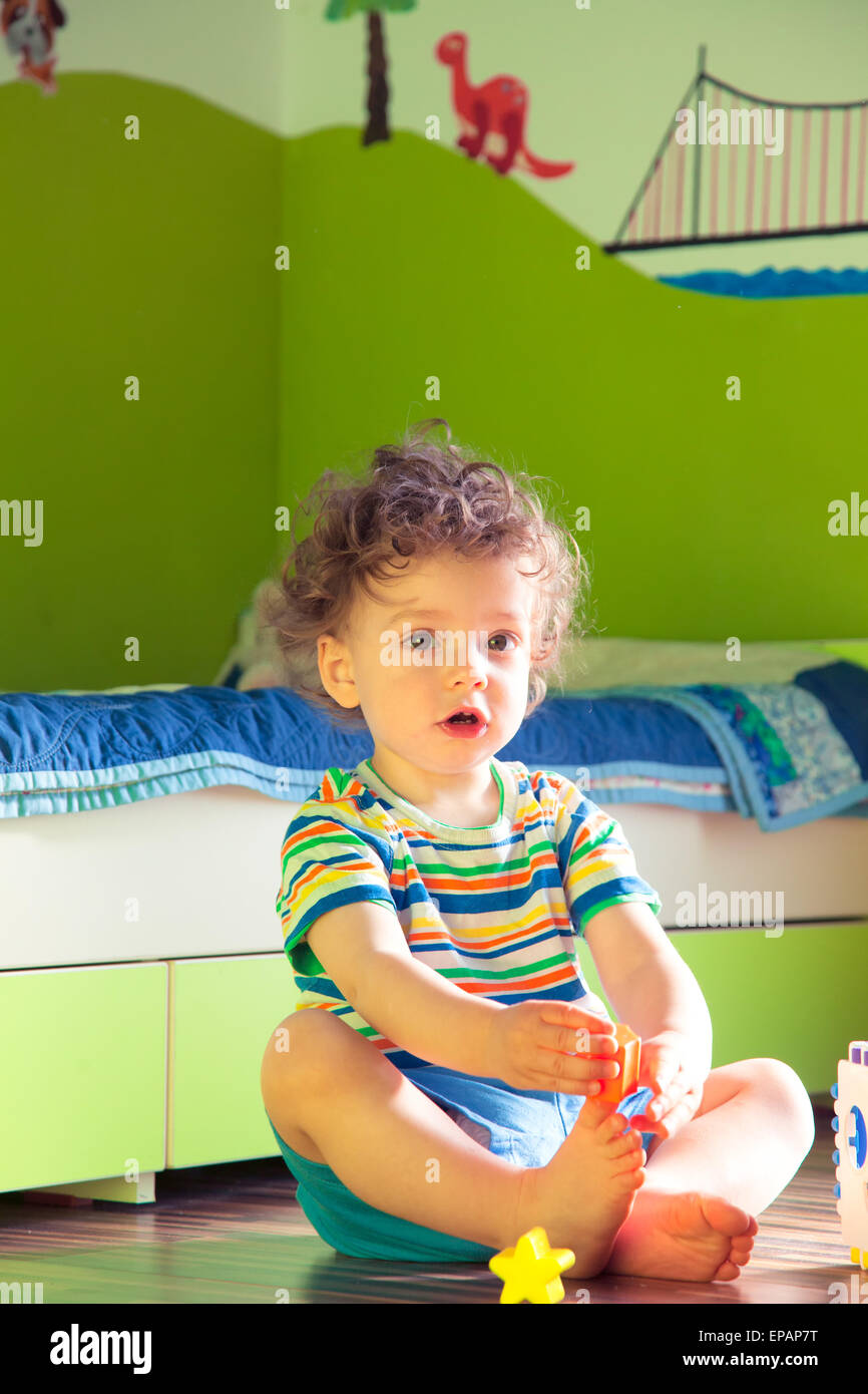 Ritratto di 1 anno di età bambino giocando nella sua splendidamente camera dipinta. Foto Stock