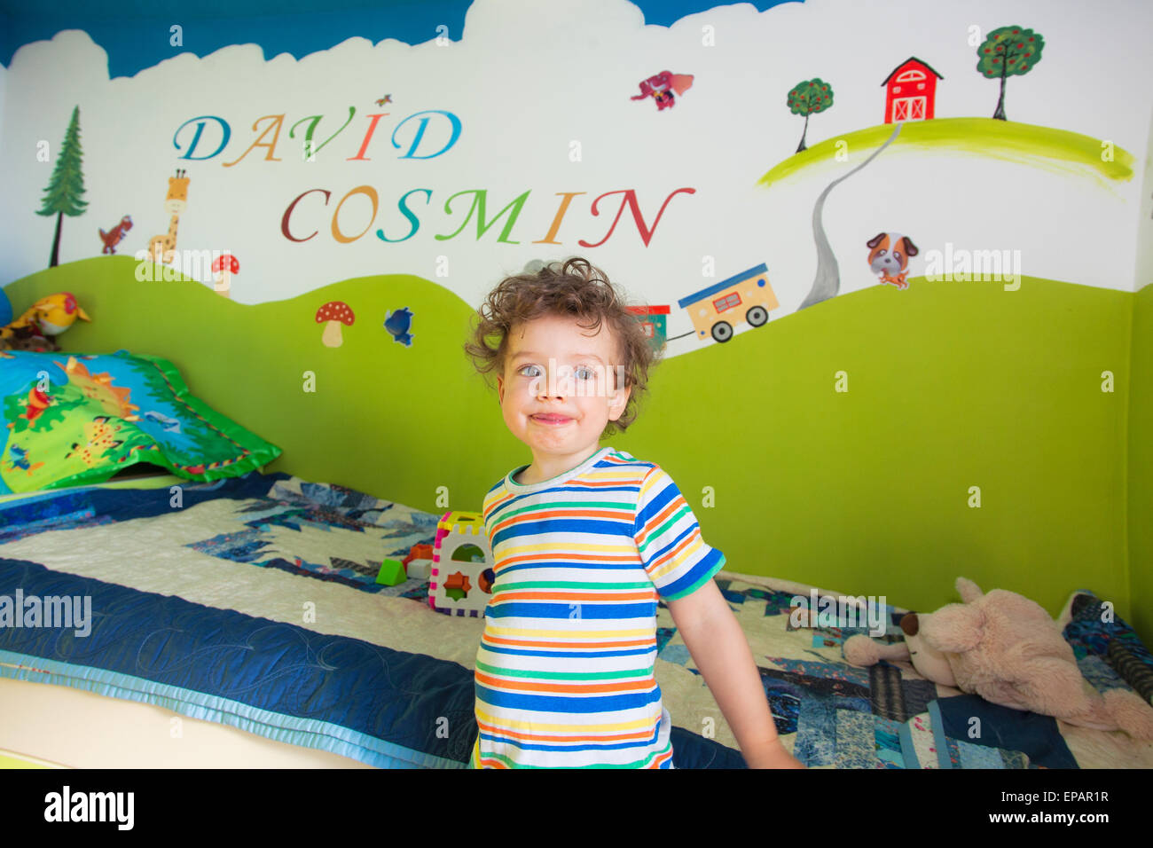 Ritratto di 1 anno di età bambino giocando nella sua splendidamente camera dipinta. Foto Stock