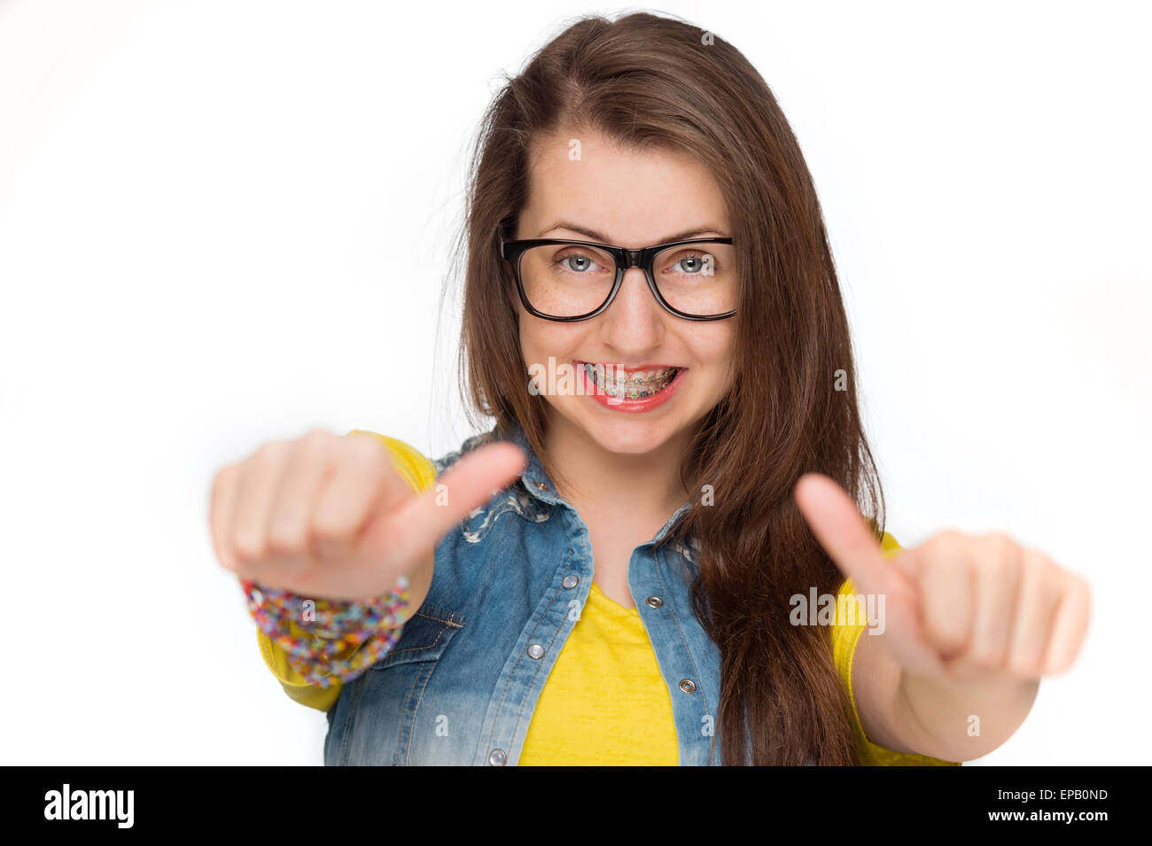 La ragazza di bretelle che mostra Thumbs up isolato Foto Stock