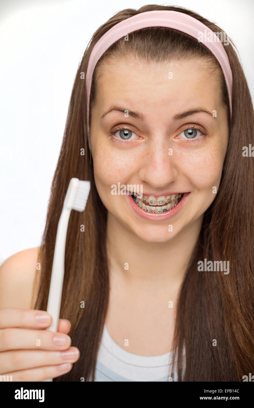 Ragazza di indossare le bretelle che mostra uno spazzolino da denti Foto Stock