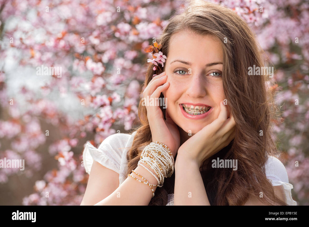 Ragazza romantica con bretelle vicino a fioritura tree Foto Stock