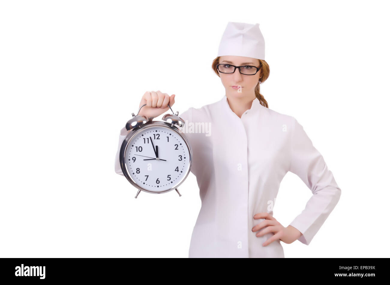 Donna attraente medico con grande orologio isolato su bianco Foto Stock
