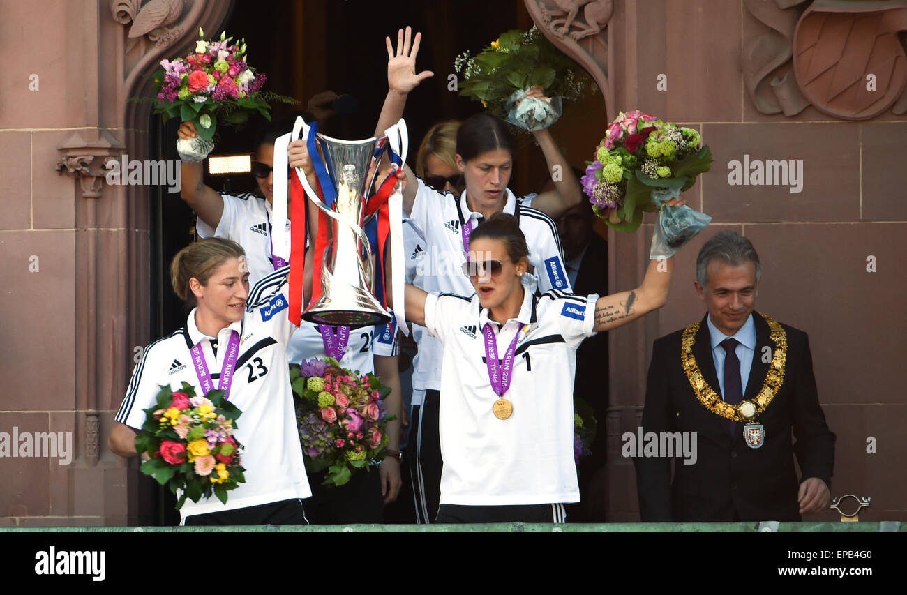 I giocatori Bianca Schmidt anteriore (l), portiere Desiree Schumann (M), Dzsenifer Marozsan, Kerstin Garefrekes indietro (r) dell'1. FFC Francoforte e Sindaco Peter Feldmann (SPD, r) con la coppa sul balcone di Rathaus Roemer in Frankfurt am Main, Germania, 15 maggio 2015. Il giorno prima, il team ha vinto la finale del femminile UEFA Champions League a Berlino contro Paris St Germain. Foto: ARNE DEDERT/dpa Foto Stock