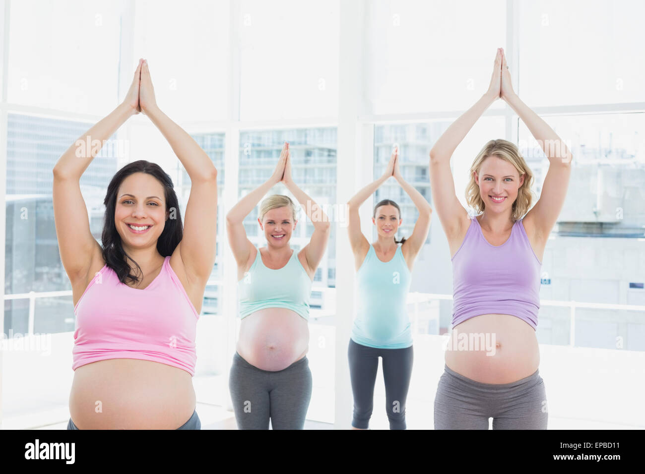 Donne in stato di gravidanza in corso di yoga in piedi in posa ad albero Foto Stock