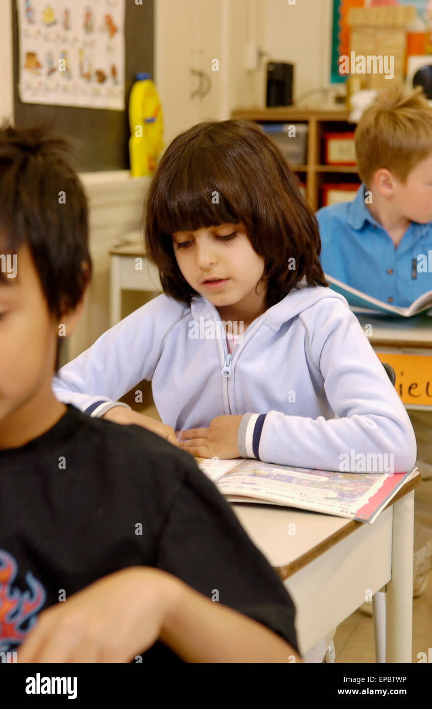 Grado 2 studenti che lavorano alle loro scrivanie in aula Foto Stock