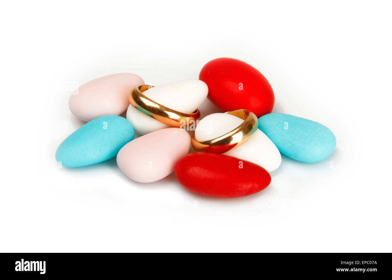 Coriandoli colorati con gli anelli di nozze su sfondo bianco. Foto Stock