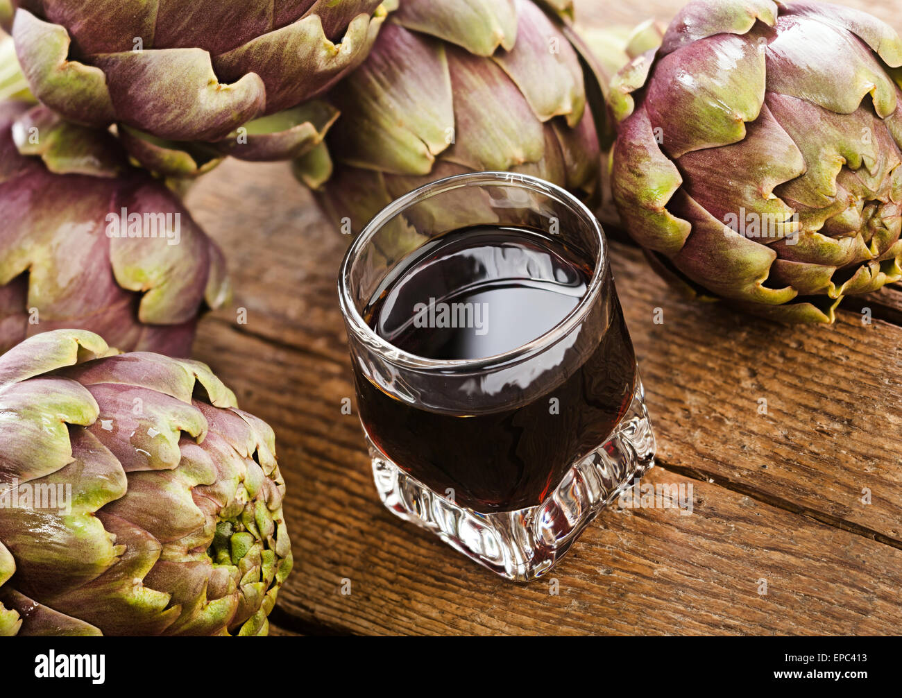 La bevanda alcolica con estratto di carciofo su un tavolo di legno. Foto Stock