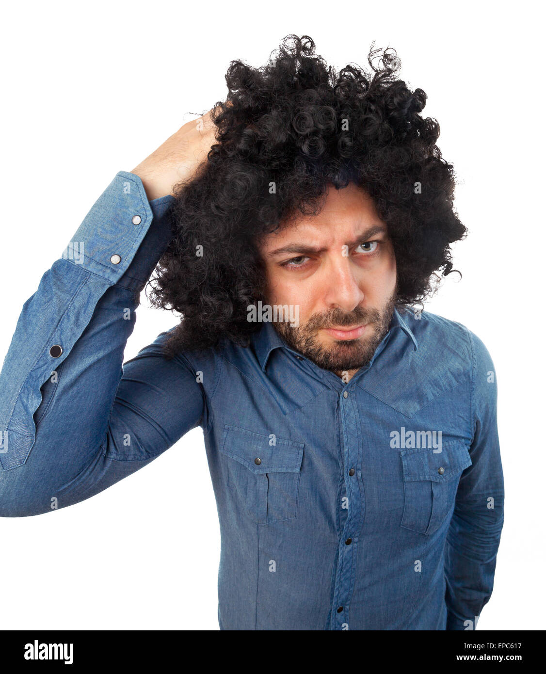 Funny Man con la parrucca mentre graffiare la testa su sfondo bianco. Foto Stock