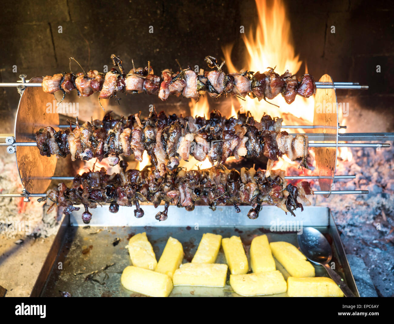 Gli uccelli ruotando allo spiedo e cuocere lentamente per il calore della fiamma del caminetto Foto Stock