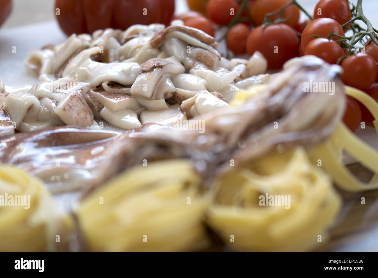 Piatto di mare con le tagliatelle con calamari anf pomodori freschi Foto Stock