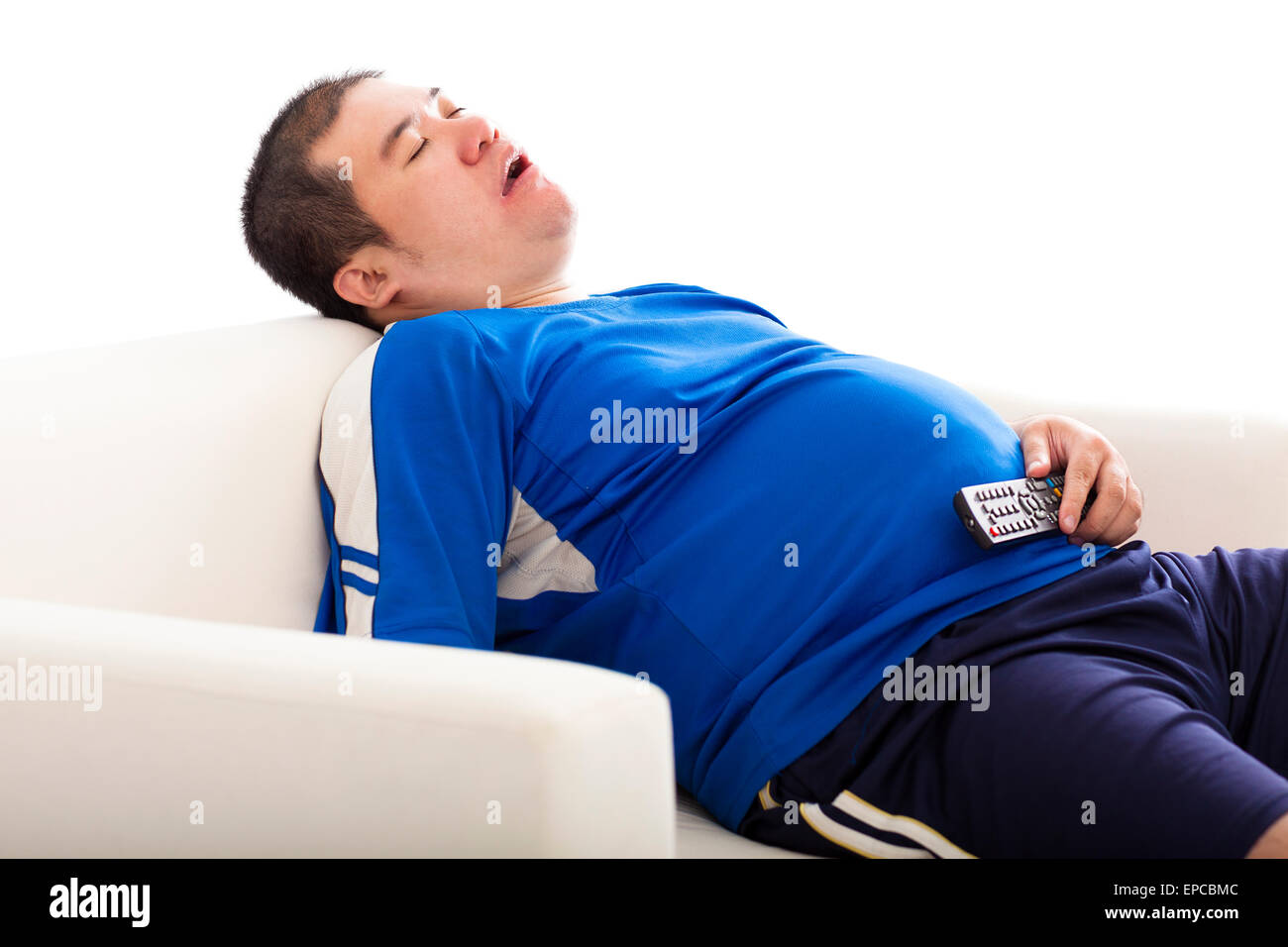Fat man di dormire sul divano e tenendo premuto il telecomando del TV Foto Stock