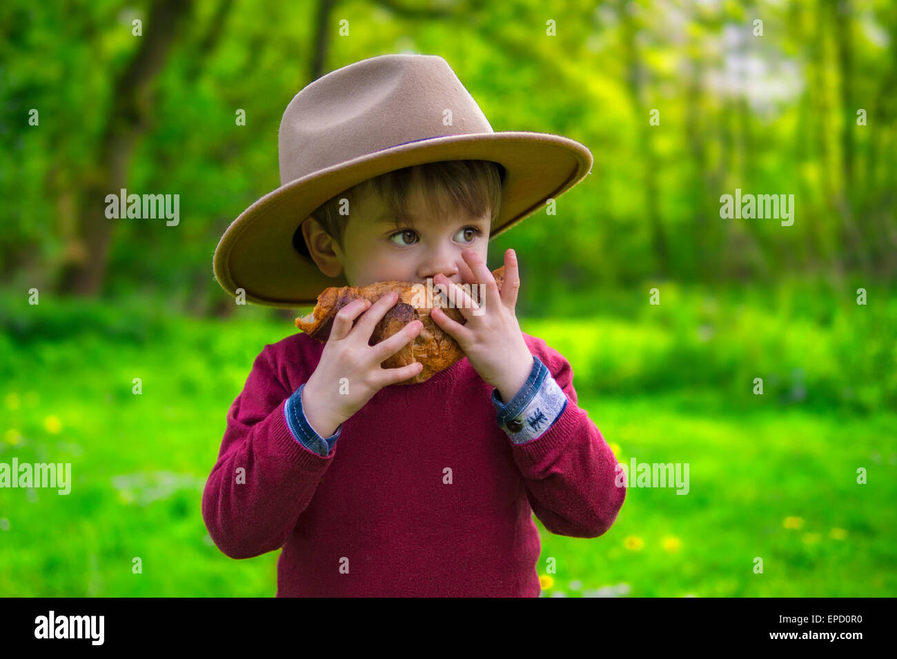 Adorable little boy mangiando un cornetto Foto Stock