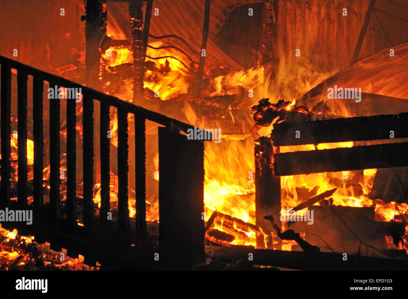 Le fiamme e il fumo salire dalla casa in fiamme Foto Stock
