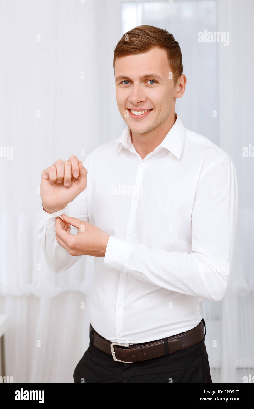 Uomo sorridente abbottonatura fino il manicotto Foto Stock