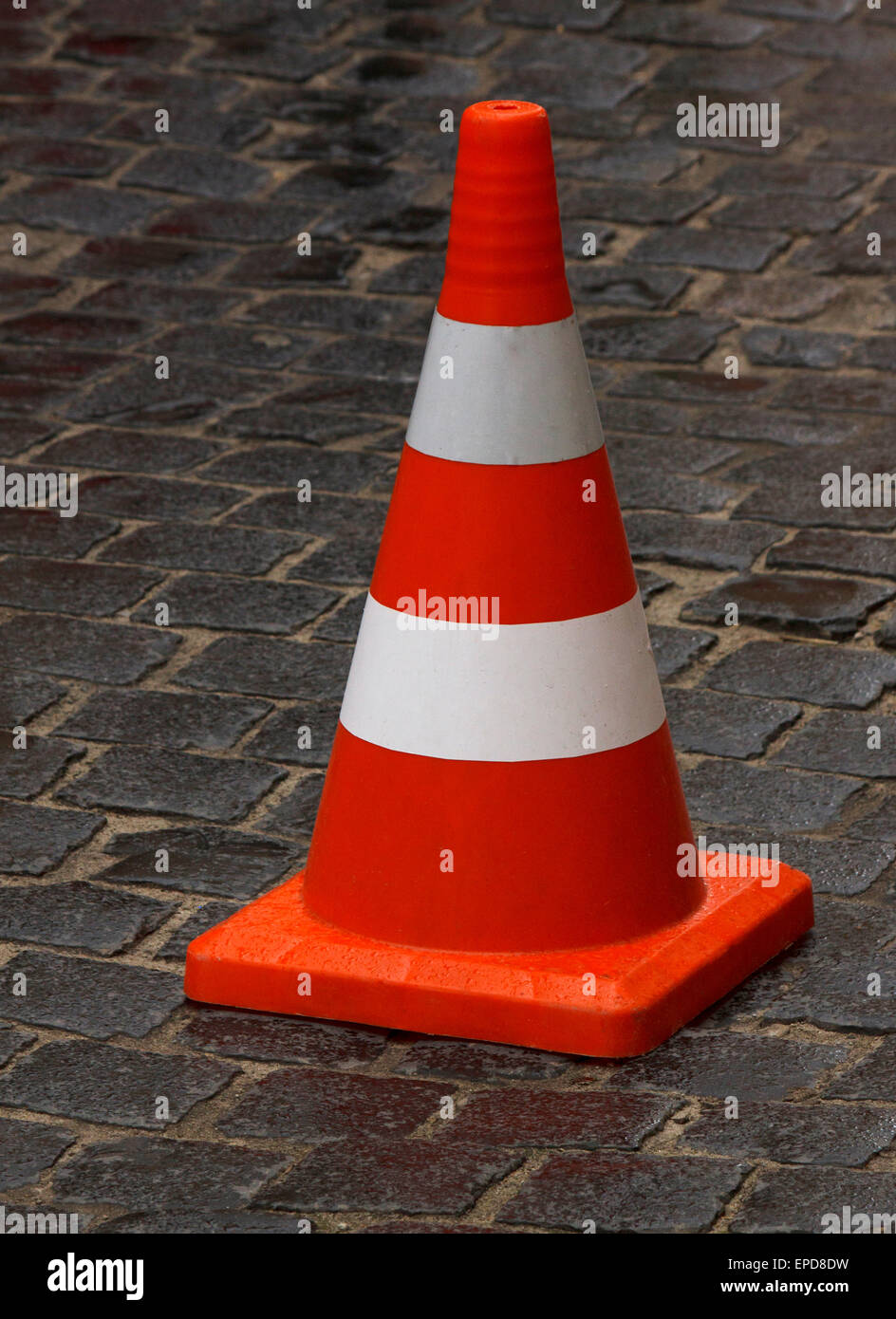 Cono stradale in piedi sul pavimento bagnato Foto Stock