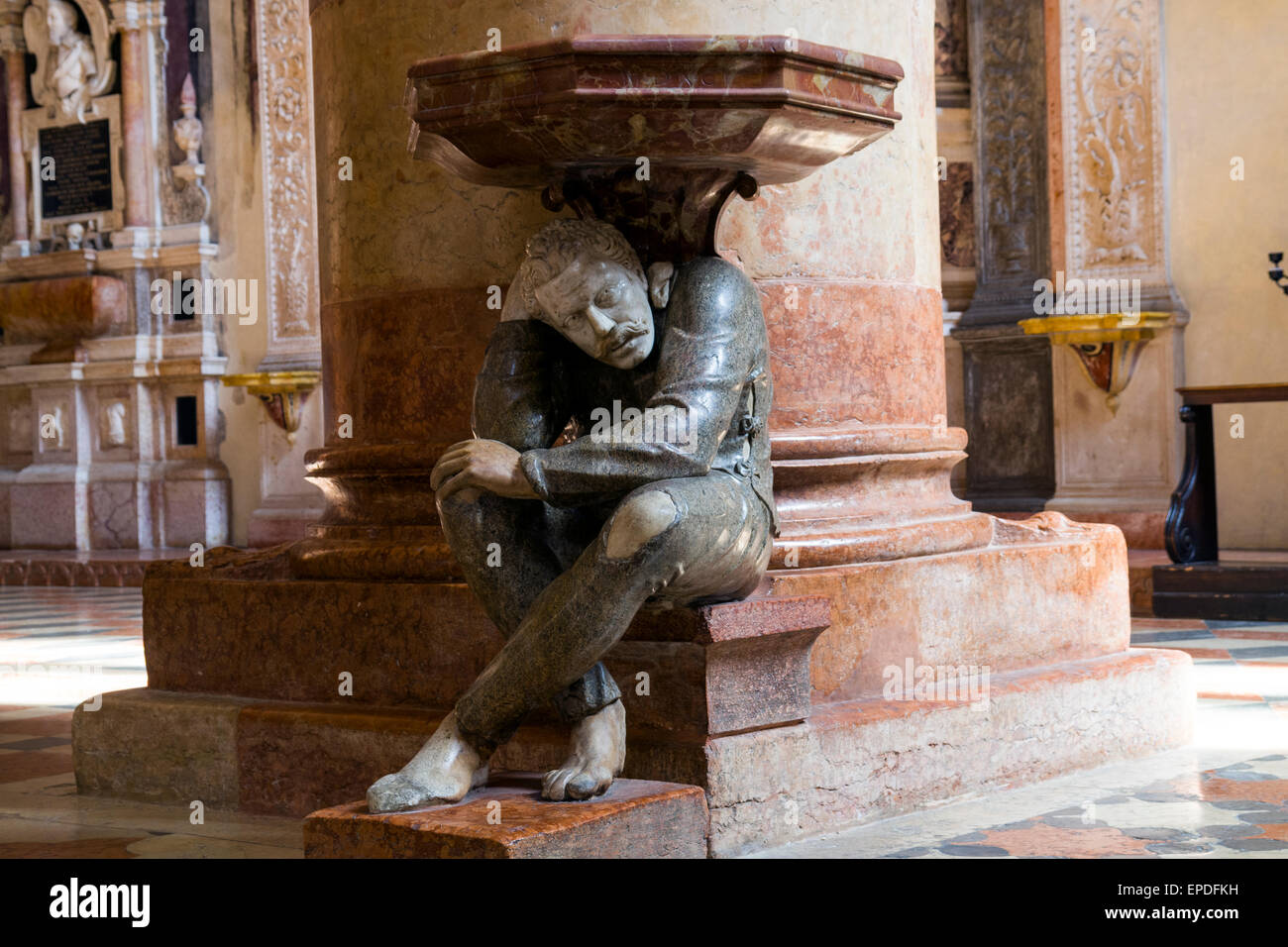 Il squatting figura sotto l'acquasantiera nella Basilica di Santa Anastasia è stato scolpito da Paolo Orefice. È noto come "Il Pasquino" Foto Stock