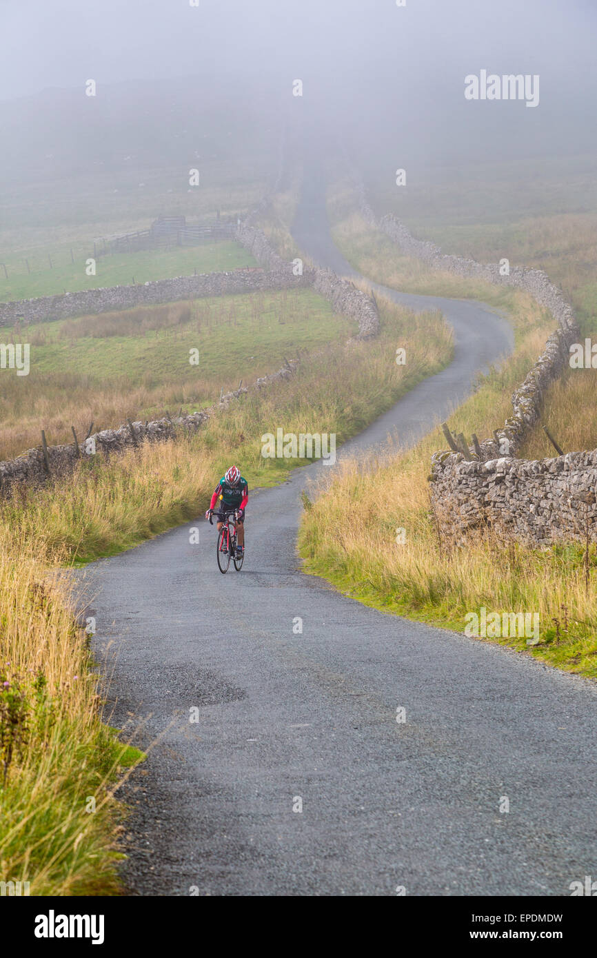 Regno Unito, Inghilterra. Ciclista pedalando in Yorkshire Dales in autunno. Foto Stock