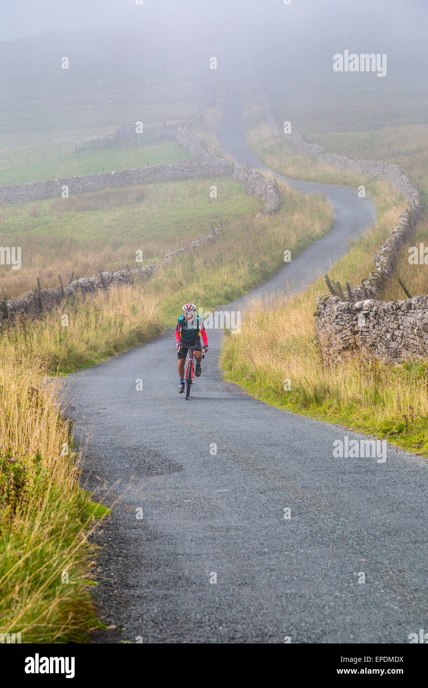 Regno Unito, Inghilterra. Ciclista pedalando in Yorkshire Dales in autunno. Foto Stock