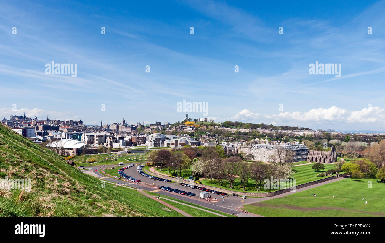 (L a R) Our Dynamic Earth, il Parlamento Scozzese e Palazzo di Holyroodhouse con parcheggio in fronte visto da Holyrood Park Foto Stock
