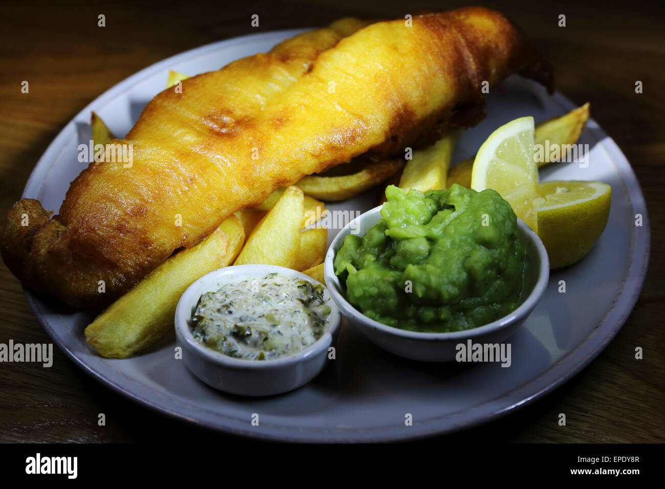 Pesce e patatine fritte servite con fiacco piselli e salsa tartara presso il St Mary's Inn near Stannington in Northumberland. Foto Stock