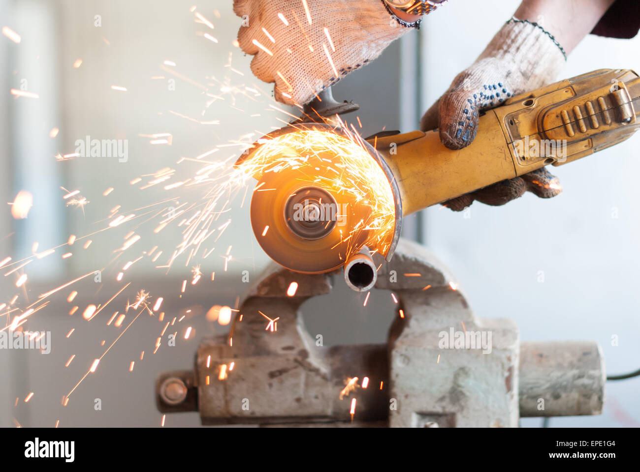 L'uomo taglia un tubo metallico. Foto Stock