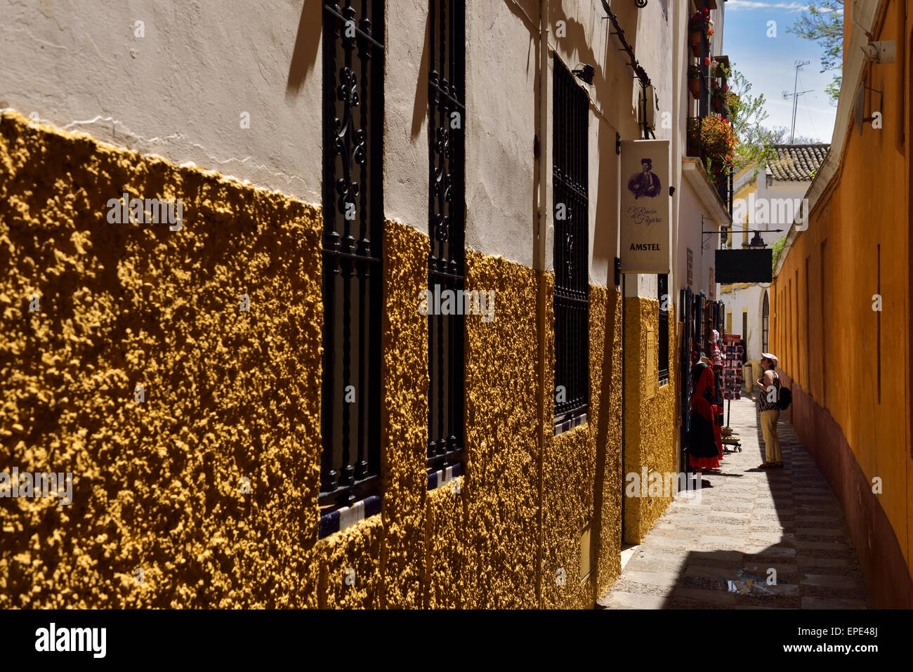 Tourist shopping nella strada stretta con stucco edifici Siviglia Andalusia Spagna Foto Stock