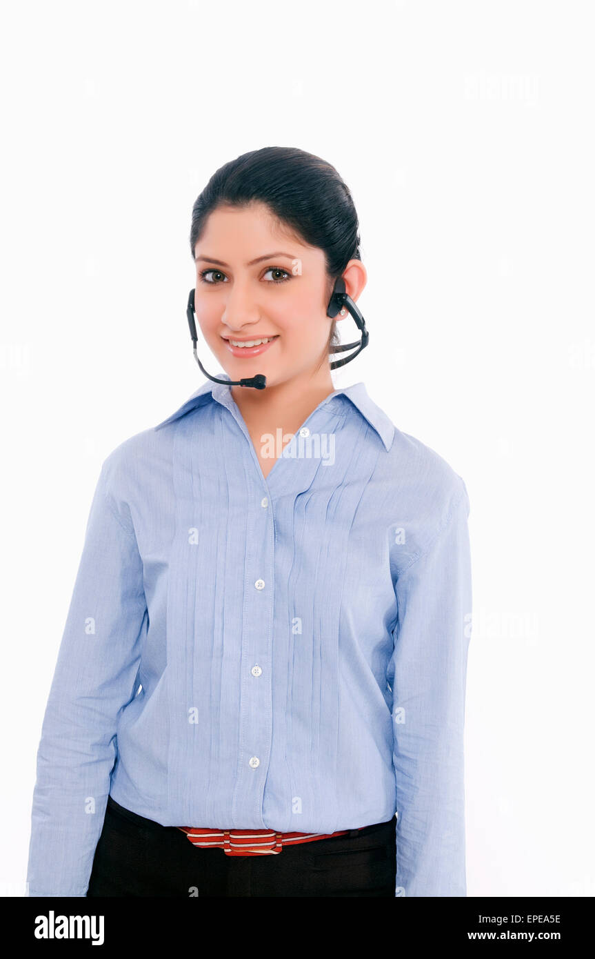 Una imprenditrice che indossano le cuffie e sorridente Foto Stock